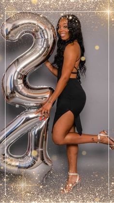 a woman posing in front of balloons and the number twenty two on it's side