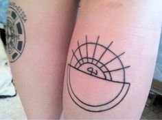 two people with tattoos on their legs, one has a sun and the other is a moon