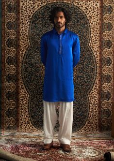 Elevate your style with our versatile blue Pathani mens kurta set, featuring subtle embroidery on the placket. Paired with a classic white salwar, this outfit is perfect for mehendi, festive occasions, or casual gatherings. Effortlessly stylish, it’s a must-have addition to your wardrobe. Blue Naqshi Straight Kurta Traditional Wear, Blue Straight Kurta With Embroidered Border, Traditional Blue Kurta With Naqshi, Long Sleeve Blue Salwar Kameez For Traditional Ceremonies, Festive Blue Traditional Wear With Naqshi, Blue Kurta With Traditional Drape For Ceremonies, Blue Salwar Kameez With Dabka For Traditional Ceremonies, Blue Bollywood Kurta For Traditional Ceremonies, Blue Kurta With Dabka In Traditional Drape Style