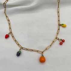 Get ready to add some deliciousness to your look with our Fruit Salad Charm Necklace! This fun accessory is adorned with vibrant enamel fruit charms that will give your outfit a burst of personality. Add some charm and quirkiness to your style with this playful necklace. 18kt gold plated enamel charms, featuring 5 charms (strawberry, blackberry, orange, cherry, and lemon) paperclip chain, links measure 12mmx4mm gold stainless steel for long-term worry-free wear with no tarnish