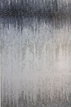 an abstract painting with white and grey colors on the wall in front of a window