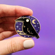 a black bird sitting on top of a purple and white pin with stars in the sky