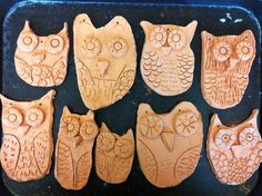 six carved wooden owls sitting on top of a pan