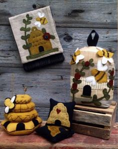 three bee themed backpacks are sitting next to each other on a wooden bench, one is yellow and the other is black