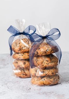 two bags of cookies wrapped in plastic and tied with a blue ribbon on the top