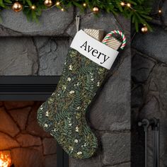 a christmas stocking hanging from a fireplace with the word avery on it's side