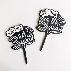 two black and white cake toppers with words on them