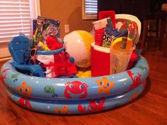 an inflatable pool filled with toys on top of a wooden floor