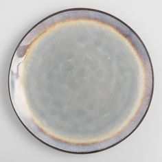 a gray and brown plate on a white surface with an orange stripe around the edge