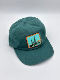 Green baseball cap featuring an embroidered patch. Cap and patch are both vintage. Cap is unstructured and adjustable in size. Any idiosyncrasies, such as signs of wear or mending, are the result of the nature of the material’s long and rich history and should not be considered flaws or damage. Vintage Trucker Hat With Logo Patch And Curved Bill, Vintage 5-panel Trucker Hat With Logo Patch, Vintage Cotton Dad Hat With Flat Bill, Vintage Cotton Dad Hat Snapback, Green Baseball Cap With Logo Patch And Curved Brim, Vintage Cotton Snapback Dad Hat, Vintage Baseball Cap With Curved Bill For Outdoor, Vintage Cotton Trucker Hat With Logo Patch, Vintage Cotton Snapback Hat With Logo Patch