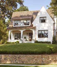 a large white house with lots of windows on the front and side of it's roof