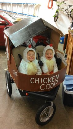 two babies dressed in chicken costumes sitting in a wagon with the words chicken coop written on it