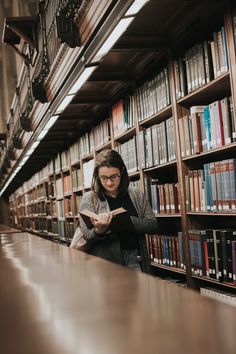 a woman reading a book in a library