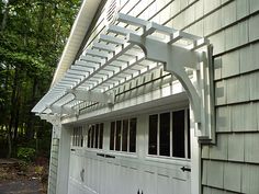 a garage with a white pergolated roof and windows on the side of it