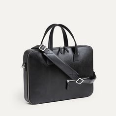 Ce briefcase Paolo propose un design très épuré. Aucune poche extérieure ne vient perturber le volume du sac en dehors de notre poche signature sur l’avant : une poche zippée permettant de venir y glisser son passeport. Un sac très compact qui vous surprendra par ses capacités de rangement ! Côté matière, ce sac est réalisé dans notre cuir Saffiano, un cuir pleine fleur de grande qualité, à l’aspect légèrement satiné et qui ne s’altèrera pas avec le temps. Les fermetures à glissières sont réalisées par YKK, un des plus grand spécialistes au monde, et nos mousquetons réalisés en laiton pour garantir une résistance maximale. Le porte-documents Paolo est proposé avec sa sangle en cuir pour un porté épaule, et vous sera livré dans un pochon de protection. Modern Top Handle Briefcase, Sleek Leather Briefcase For Formal Occasions, Modern Laptop Bag With Smooth Grain For Travel, Black Saffiano Leather Briefcase For Work, Saffiano Leather Business Briefcase Satchel, Saffiano Leather Satchel Briefcase For Business, Business Saffiano Leather Satchel Briefcase, Luxury Saffiano Leather Satchel Briefcase, Sleek Business Shoulder Bag With Smooth Grain