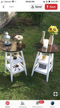 two small tables sitting in the grass with sunflowers