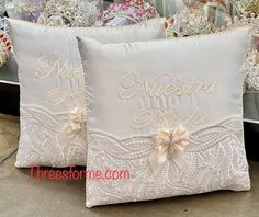 two white pillows with bows on them sitting in front of a store display filled with christmas decorations