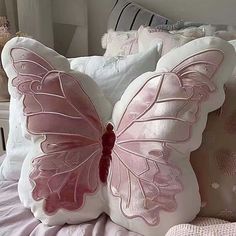 a pink butterfly pillow sitting on top of a bed