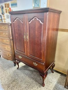 an old wooden armoire sitting on top of a carpeted floor