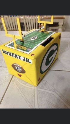 a green bay packers football game in a box on the floor with chairs around it