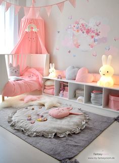 a bedroom with pink and white decor on the walls, bedding and rugs