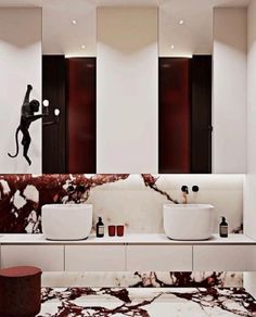 a bathroom with two sinks, mirrors and a monkey wall sticker on the wall