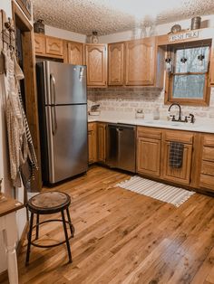 a kitchen with wooden floors and stainless steel appliances