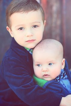 two young boys are hugging each other