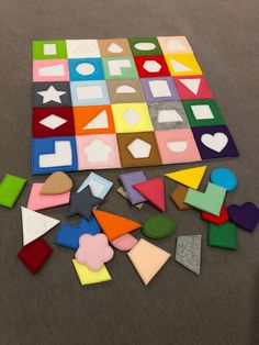 an assortment of different colored shapes and sizes on the floor in front of a wall