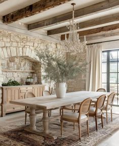 a dining room table with chairs and a chandelier hanging from it's ceiling