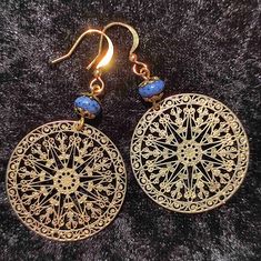 Golden ethno hanging earrings with a filigree, matt gold mandala pendulum and a small lapis lazuli pearl. The ear hooks are made of 18K gold plated brass.  Total length: 5.4 cm  Pendulum length: 4.0 cm  Width: 3.0 cm  Weight: approx. 4.2 g.  Colours: blue, golden Gold Lapis Lazuli Pierced Earrings, Gold Pierced Earrings With Lapis Lazuli, Gold Lapis Lazuli Earrings, Gold Lapis Lazuli Drop Earrings, Traditional Gold Lapis Lazuli Jewelry, Traditional Gold Jewelry With Lapis Lazuli, Gold Lapis Lazuli Pierced Jewelry, Gold Lapis Lazuli Jewelry, Handmade Gold Lapis Lazuli Earrings