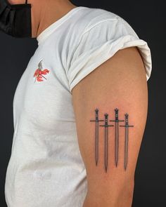 a man's arm with three swords on it