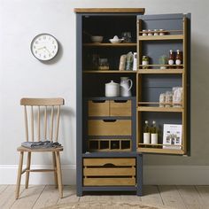 a wooden chair sitting next to a cabinet with drawers and shelves on it's sides