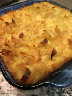 a casserole dish with pineapple toppings in a blue pan on a marble countertop