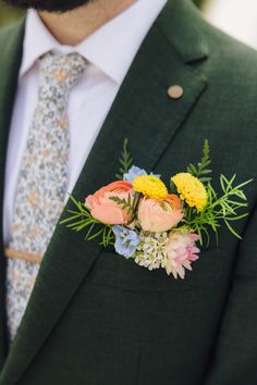 a man wearing a suit and tie with flowers in his lapel flower pinion