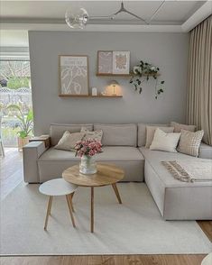 a living room with gray walls and white carpeted flooring, a large sectional sofa is on the far wall