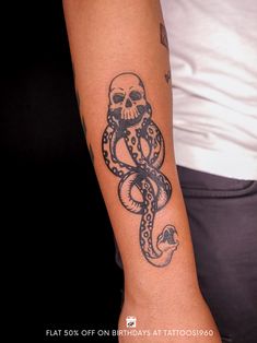 a tattoo on the arm of a man with a skull and octopus in black ink