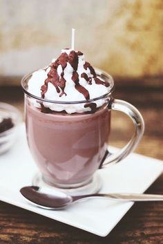 hot chocolate in a glass mug with whipped cream and drizzled on top