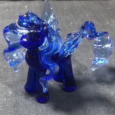 a blue glass pony figurine sitting on top of a table