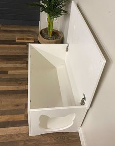 a plant is sitting in the corner of a white cabinet next to a potted plant