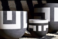 two black and white vases sitting on top of a rug next to each other