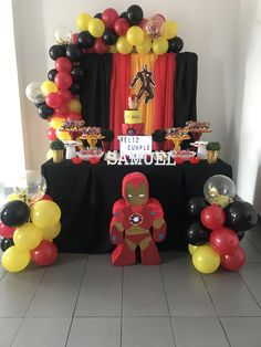 an iron man themed birthday party with balloons and cake table set up for the event