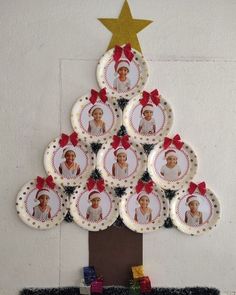 a christmas tree made out of plates with pictures on it's side and gold star