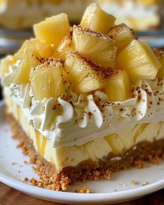 a piece of cake with pineapples and whipped cream on top sits on a plate