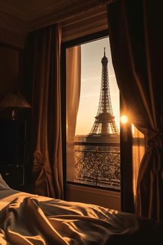 the eiffel tower is seen through an open window in this dark room with curtains