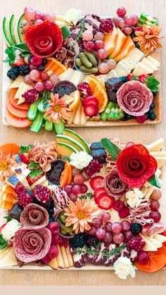 two square trays filled with fruit and flowers on top of a wooden table next to each other