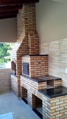 an outdoor fireplace made out of bricks in the middle of a room with tile flooring