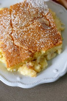 a piece of cake sitting on top of a white plate covered in powdered sugar