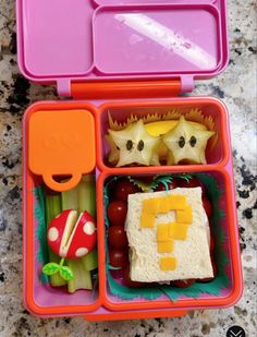 a pink lunch box filled with lots of food