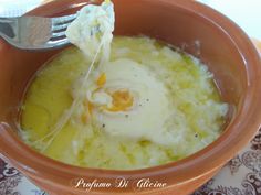 a bowl filled with soup and an egg being drizzled on top of it